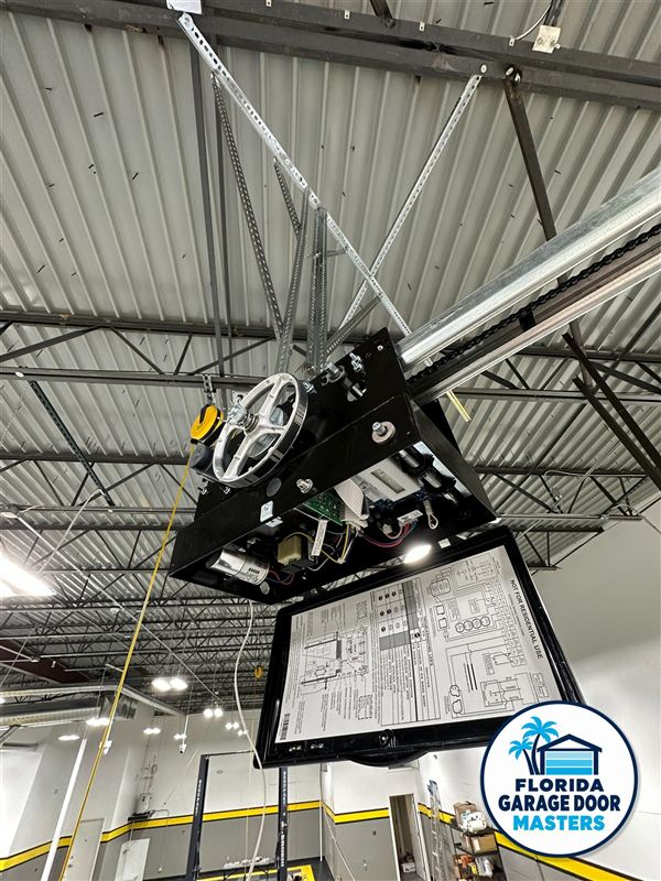 Commercial jackshaft door operator and control box mounted under a steel roof