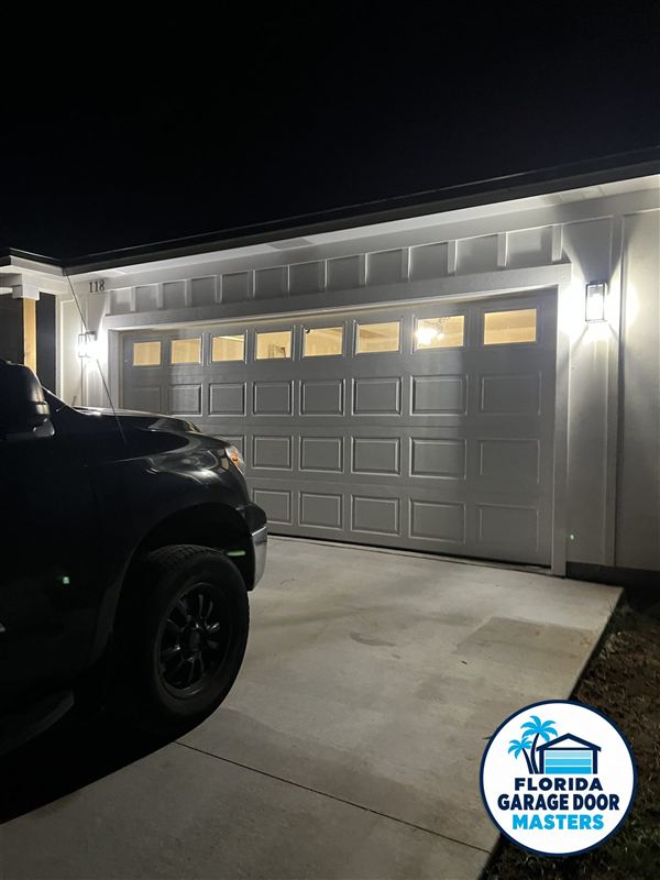 New double garage door with window top section, lit at night