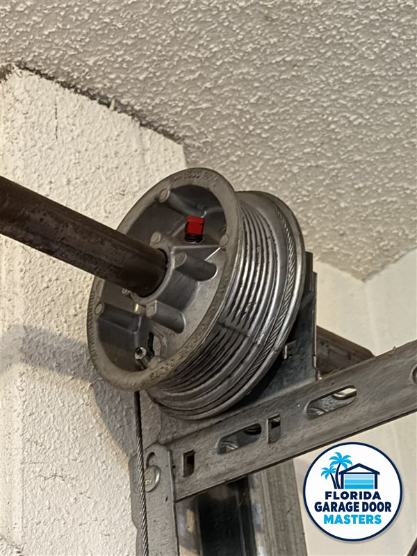 Garage door cable drum and end bearing bracket on the torsion shaft