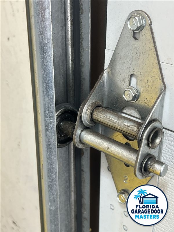 Garage door roller and hinge seated in the vertical track