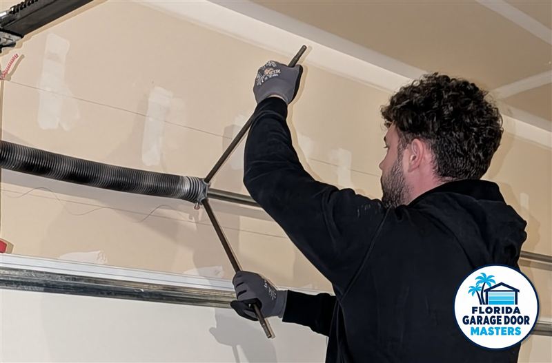 Technician winding a new torsion spring with winding bars