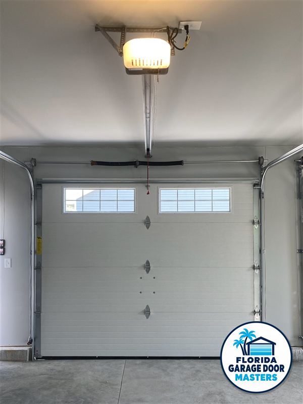 Inside view of an insulated white garage door with window section and new hardware