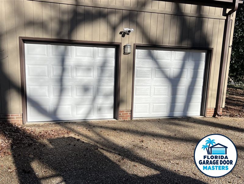 Two new white raised-panel single garage doors installed by Florida Garage Door Masters